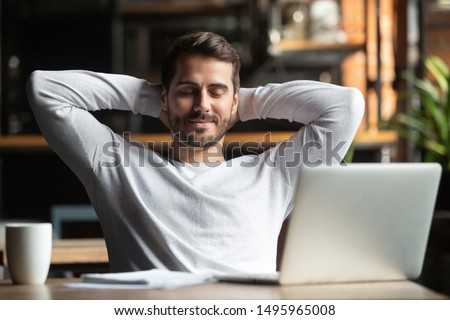 Relaxed happy businessman student worker lounge at work desk cafe table meditating, positive calm man relax break hold hand behind head dream rest from computer stretch feel no stress peace of mind 商業照片 © 
