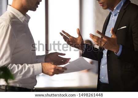 Close up executive manager dissatisfied by African American employee work results, holding financial report with stats, colleagues arguing, discussing business failure, partners disputing at work Сток-фото © 