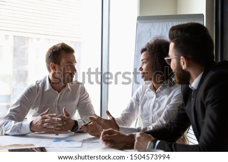 Multi-ethnic business partners lead by african chief executive officer analyzing financial situation of company in modern boardroom, corporate financiers reviewing stats and charts at group meeting ストックフォト © 