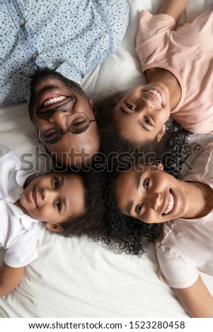 Similar – Image, Stock Photo Vertical photo of a child sitting with headphones on a sofa touching the screen of a tablet at night