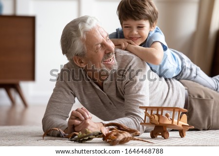 Foto Bild Älterer Mann und Junge essen Erdbeere im Garten