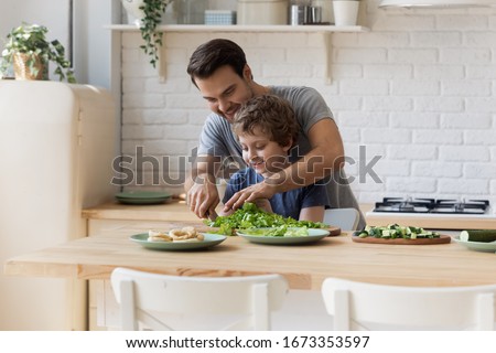 Similar – Image, Stock Photo Young boy is making a wooden  bird house in the carpenter workshop. Curious little sister is trying to see what he is doing behind his back