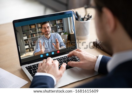 Back view of businessman talk with male business partner using video call on laptop discuss work project online, male client talk with colleague or coworker, speak on webcam conference on computer Stock foto © 