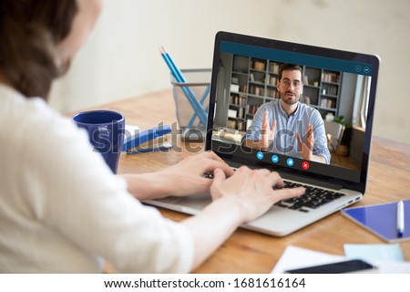 Back view of female employer talk interview confident male job applicant via online video call on laptop, businesswoman speak hire work candidate or consult client, use webcam conference on computer