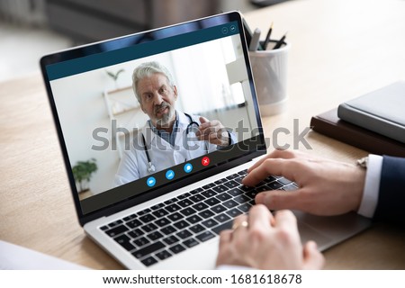 Close up of male patient talk consult with doctor using video call on laptop, man speak discuss health problem with physician on webcam virtual conference from home, online consultation concept