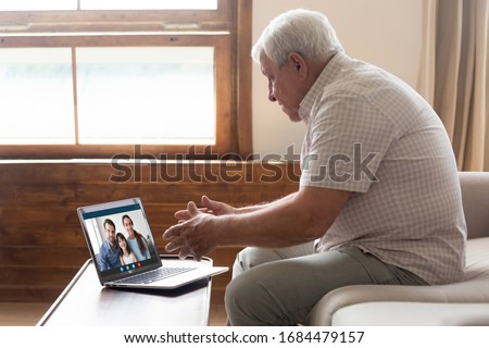Happy elderly mature 80s man holding video call with family grown up children and granddaughter, communicating online via laptop videoconference application, staying at home isolation, virus outbreak.