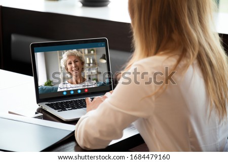 Focus on screen with happy middle aged hoary woman making video call with grown up young daughter woman, chatting communicating online using computer application, staying at home at quarantine.