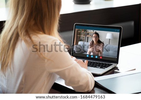 Young girl student woman holding educational video call with teacher on computer, learning foreign language online from home, using videoconference application, chat communicate distantly with friend.