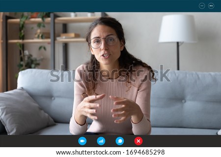 35s female teacher teach by video call explain educational material to trainee distantly seated on couch in living room at home. Friends communicating use videoconference app concept, pc screen view Foto stock © 