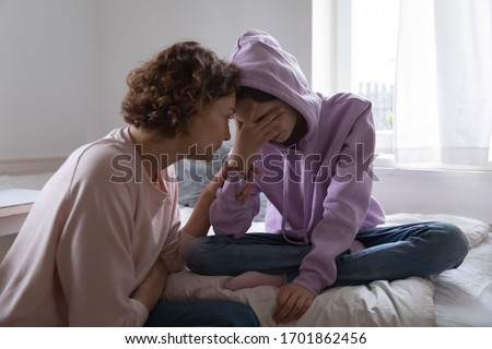 Worried parent young mom comforting depressed crying teen daughter bonding at home. Loving understanding mother apologizing or supporting sad teenage girl having psychological puberty problem concept. Foto d'archivio © 