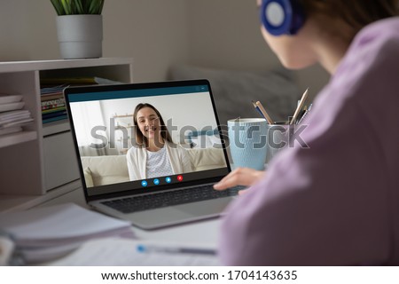 Pc screen view over woman shoulder, two girls best friends chatting using virtual modern video conference application communicating from home enjoy distant talk. Teacher teach learner remotely concept