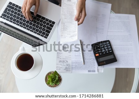 Above top view close up young woman holding utility bills or receipt, managing monthly expenses with e-banking application on computer, professional accountant or bookkeeper doing paperwork indoors. Photo stock © 