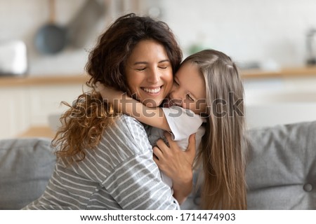 Affectionate beautiful young woman cuddling small preschool child daughter, feeling happiness. Cute little kid girl embracing loving mommy, feeling thankful, enjoying tender sweet time at home. Stockfoto © 