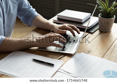 Close up businessman using laptop, typing on keyboard, sitting at wooden desk with documents, writing email, accountant writing financial report, busy student studying online, searching information Foto d'archivio © 