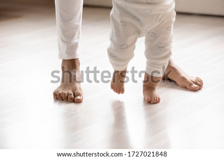 Similar – Image, Stock Photo Toddler standing with legs apart while holding onto to crib rails: nursery with peach, gray and white decor