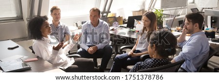 Diverse employees gathered brainstorming together in co working office, staff listen team leader, African woman share ideas, offer solutions concept. Horizontal photo banner for website header design