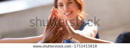 Horizontal photo banner for website header design, group of diverse young people giving high five feels excited close up focus on stacked palms. Respect and trust, celebration and friendship concept