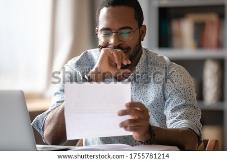 African man sit at desk hold postal correspondence letter read good news feel proud by personal business achievement, got hired, receive reward, financial success statement, approved bank loan concept