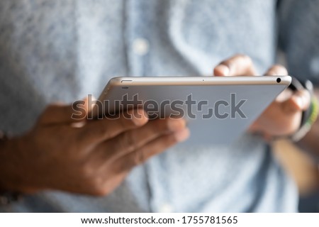 Close up hands African man holding digital tablet device. E-commerce websites buy in internet on-line stores usage, typing e-mail to client, reading sending message to friends, e-date website concept
