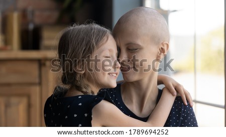 Happy young Caucasian cancer patient sick mother and little daughter hug show love and care, supportive small girl child embrace caress ill hairless mom suffer from oncology, feel grateful thankful