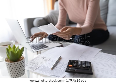 Crop close up of economical woman work on laptop at home pay bills taxes on gadget online, provident female calculate finances expenditures on machine, manage plan family household budget on computer