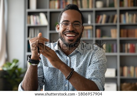 Head shot portrait smiling African American man wearing glasses making video call, looking at camera, confident positive young coach leading remote lesson, businessman participating online conference
