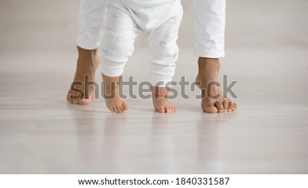 Similar – Image, Stock Photo Toddler learning to walk using push toy; child reaching to play with toy on front of walker