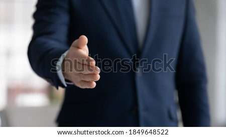 Close up crop image young businessman reaching out hand for shaking, proposing good deal to partner, making greeting gesture to client, welcoming new employee at work, congratulating with achievement. Foto d'archivio © 