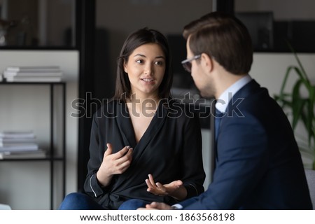 Concentrated millennial indian female candidate on vacant place answering question of male hr introducing herself on job interview, attentive man client listening to mixed race woman expert consultant Photo stock © 