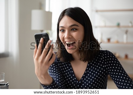 Head shot surprised young asian vietnamese woman reading message with unexpected news, happy client wins online shopping promo code or gets prize in social network giveaway, good luck concept.