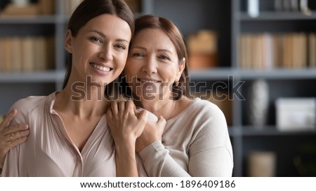 Image, Stock Photo Happy mature mom and her blonde little daughter hugging and laughing while walking in autumn park outdoors