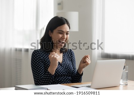 Excited young vietnamese woman look at laptop pc screen in delight receiving good news being accepted admitted to college university. Overjoyed asian lady office worker get reward promotion by email