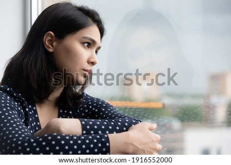 Profile of stressed young asian lady sitting on sill by window think hesitate unable to make choice in hard situation. Suffering teen vietnamese female with depressed look has life crisis. Copy space Foto d'archivio © 