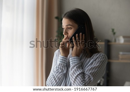 Sad millennial woman has difficult phone talk hold gadget by ear listen to unexpected bad news think on answer. Compassionate young lady support friend by cell try to help ponder on advice. Copy space