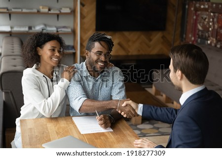 Grateful black family couple handshake with bank manager insurer lawyer thank for consultation before sign contract. Satisfied young african husband wife real estate buyers make deal with male broker