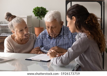 Close up manager realtor advisor consulting mature couple about contract terms at meeting, senior family involved in negotiations, making insurance or investment deal, purchasing real estate