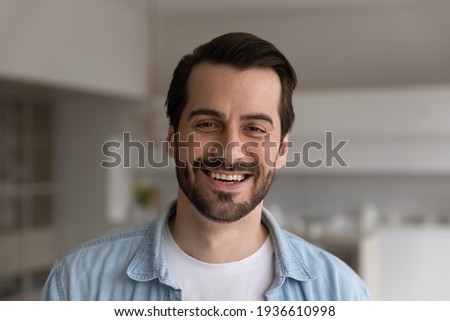 Close up headshot portrait of smiling 30s Caucasian man look at camera posing in own flat or apartment. Profile picture of happy 20s male renter or tenant in new home. Real estate, rental concept.