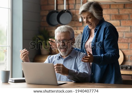 Great surprise. Overjoyed mature married couple on pension scream in delight getting unexpected news of prize award by email. Excited old age spouses read about cash reward in betting on laptop screen