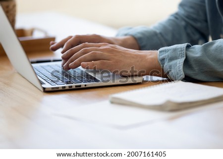 Close up view male hands writes on laptop. Entrepreneur man sit at desk work on modern wireless notebook, do remote telecommute, search information on internet, professional application usage concept 商業照片 © 