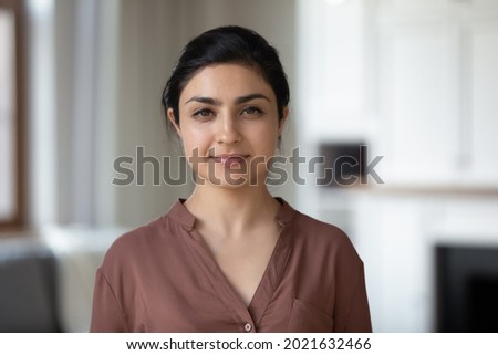 Headshot portrait of confident young Indian woman renter or tenant pose in modern own new apartment or house. Profile picture of millennial mixed race female look at camera. Diversity concept.