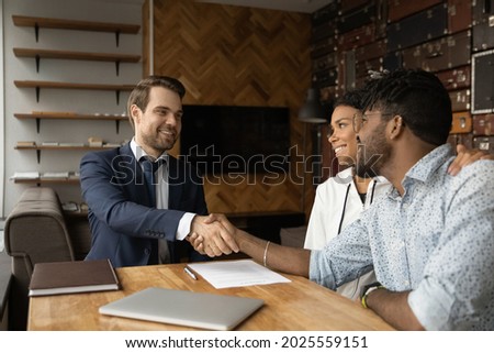 Happy African family after sign contract shake hands bank advisor. Make financial deal at meeting, successful negotiations, real estate buyers making deal with male broker agent, take mortgage concept