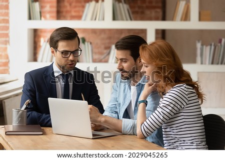 Real estate agent make offer for couple selects housing options, showing services presentation on laptop, choose new or secondary property for long term rental. Family and advisor discuss deal concept Foto d'archivio © 