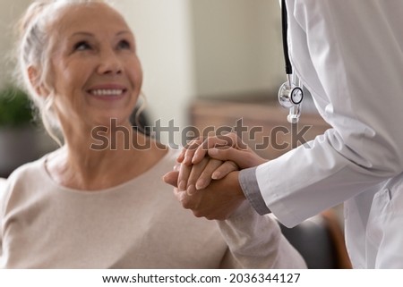 Happy senior woman visiting doctor, getting optimistic news after medical checkup, therapy. Therapist holding hand of old patient, giving hope, support, congratulating on goor treatment result Imagine de stoc © 