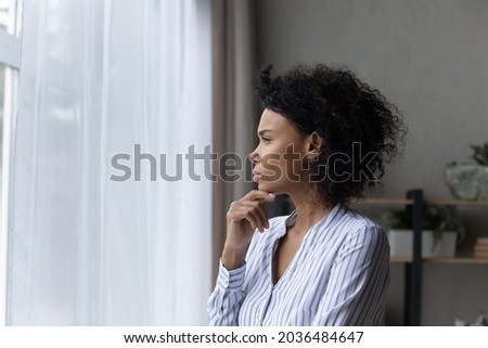 Visualizing perspectives. Serious contemplative black businesswoman young leader look at office window touch chin deep in thoughts solve business problem in mind create new sales strategy. Copy space Foto d'archivio © 