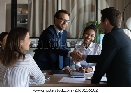 Nice to meet you in our team. Friendly man leader boss shake hand of new staff member welcome young male on job in corporate department. Professional businesspeople reached agreement on negotiations Stockfoto © 