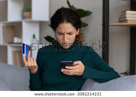 Internet scam. Concerned young hispanic lady looking on smartphone screen having finance savings stolen from bank card as money fraud result. Upset nervous latin woman become online scammers victim Foto d'archivio © 
