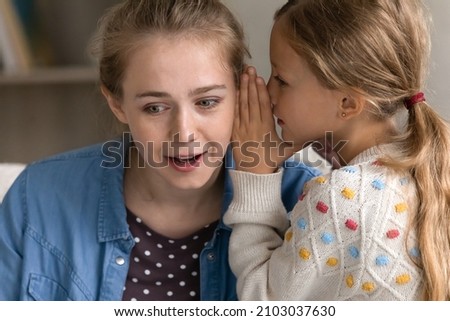 Curious happy young mother listening to secret, joyful preteen kid girl whispering on ear, telling confidential information or gossiping at home, trustful conversation, sincere relations concept. Foto stock © 