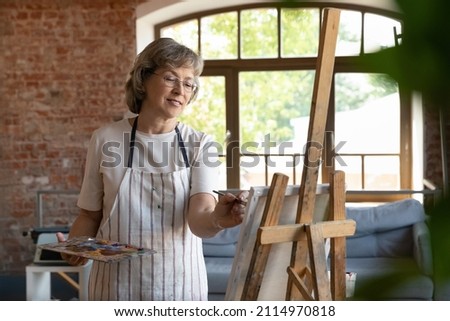 Similar – Image, Stock Photo Senior artist standing in home workshop and choosing paints