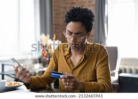 Concerned African credit card user woman having problems with online payment app on mobile phone. Worried puzzled bank customer confused, distressed with virtual finance service error, mistake Foto d'archivio © 