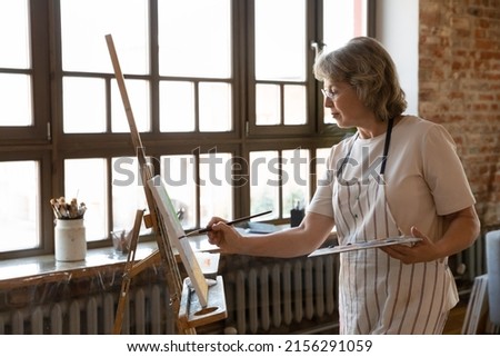 Similar – Image, Stock Photo Older woman painting on a notebook